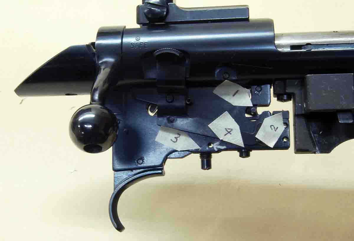 This is a Japanese Model 52C trigger showing the engagement surface: (1) the engagement adjustment that isn’t there, (2) pull weight, (3) overtravel and (4) the pull-limiting pin (small silver arrow).